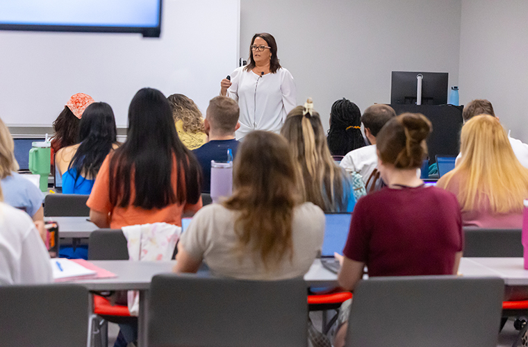 Students listening to professor's lecture in a nursing classroom